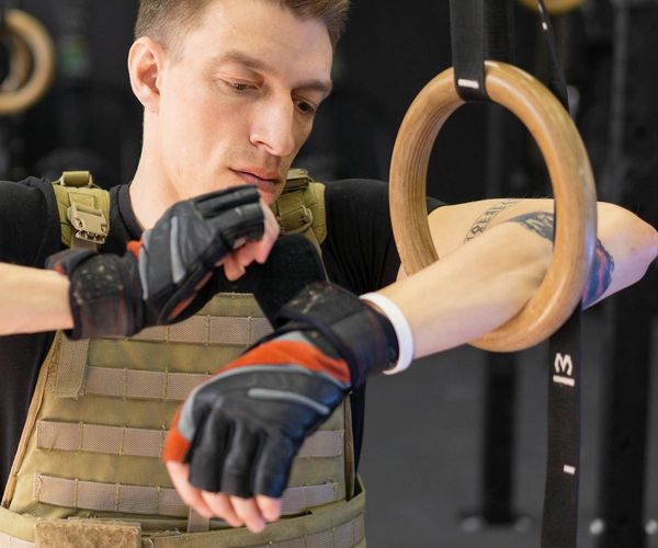 A focused man in athletic wear holding a kettlebell, preparing for a lift.